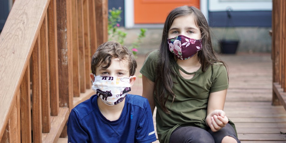 two children in covid-19 face masks 